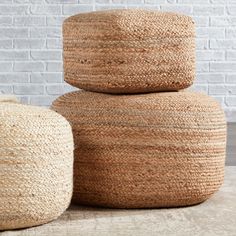 three woven baskets stacked on top of each other in front of a white brick wall