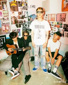 three young men are posing with their guitars