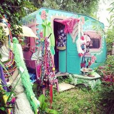 an old trailer is decorated with colorful decorations and accessories for the costumed woman to wear