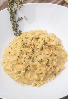 a white plate topped with macaroni and cheese on top of a wooden table