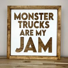 a wooden frame with the words monster trucks are my jam printed on it in brown