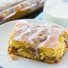 a piece of cake sitting on top of a white plate next to a glass of milk