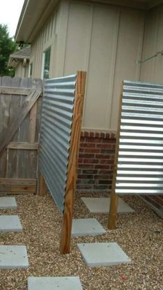 an outdoor area with gravel, brick and metal fenced in to the back yard