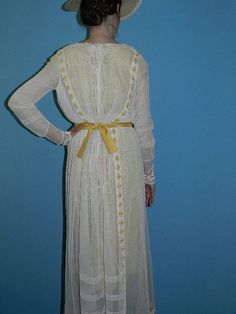 This beautiful original antique Edwardian dress would be great for a vintage Victorian wedding, garden or Downton Abbey party with its classic look in off white with mustard color accents and lovely straw hat. The dress is 2 layers of cotton net with a bodice that blossoms over the waist band in the front. The flat collar in the front and back is of antique embroidered lace along with the sleeve cuffs. The very interesting design of mustard colored embroidered diamond decals originate along the