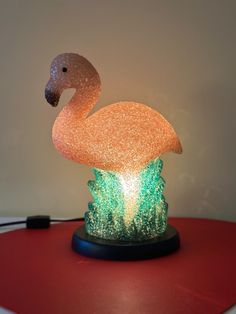 a flamingo lamp sitting on top of a red table