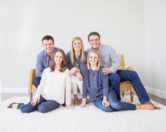 a group of people sitting on top of a white rug