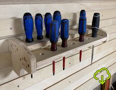 there are many different tools in the holder on the rack, including drillers and screwdrivers