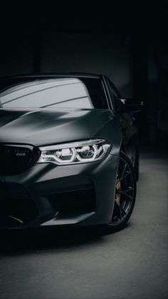 the front end of a black car in a dark room