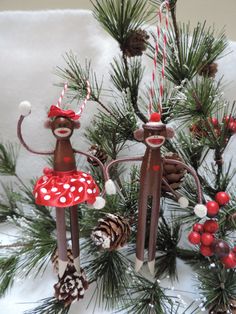 two christmas decorations made to look like people in the snow with pine cones and candy canes