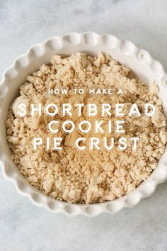 a white bowl filled with shortbread cookie pie crust on top of a marble counter