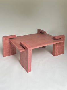 a table made out of red clay with two legs on each side and one end missing