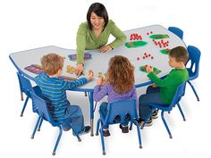 a woman and children sitting at a table playing with magnets on the board game