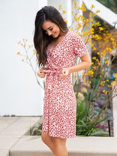 Get ready to turn heads with our stunning Berkeley Dress in Rust Floral! Perfect for any occasion, this dress features a flowy silhouette that is both fun and flirty. The faux wrap style and knee-length make it a versatile piece that can be dressed up or down. We are obsessed with the bold floral prints that add a pop of color and make styling a breeze. Whether you're headed to brunch with friends or a night out on the town, this dress is sure to make you feel confident and stylish. Size: Small V-neck Wrap Dress With Tie Waist For Garden Party, Flowy Faux Wrap Dress For Spring, Flirty Dresses With Tie Waist And Surplice Neckline, Feminine Flowy Wrap Dress With Surplice Neckline, Flirty Spring Wrap Dress With Tie Waist, Flirty Tie Waist Wrap Dress For Brunch, Flowy Midi-length Wrap Dress With Tie Waist, Flowy Midi Dress With Surplice Neckline, Flowy Wrap Dress With Surplice Neckline For Brunch