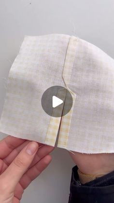 someone is cutting up the side of a piece of fabric to make a doll's head