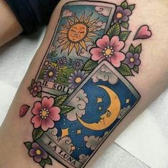 a tattoo on the leg of a woman with flowers and a moon in it's box