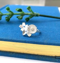 This sterling silver summer flower ring is a perfect piece of elegant jewellery designed to captivate and delight. This beautiful ring is not only a timeless accessory but also a thoughtful gift for your loved one on their special day. This stunning ring features three enchanting summer flowers - a radiant sunflower, delicate cherry blossom, and a graceful leaf, symbolising growth and rejuvenation. Each element has been meticulously detailed to showcase the intricate beauty of nature. The vibran Birthday Present For Friend, Buttercup Ring, Present For Friend, Birthday Presents For Friends, Summer Jewellery, Handmade Sterling Silver Rings, Ring Flower, Leaf Motif, Presents For Friends