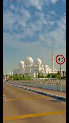 an image of a street sign in front of a large white building with domes on it