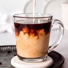 a glass cup filled with liquid sitting on top of a plate