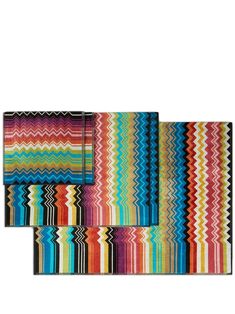 three multicolored placemats with different patterns on the top and bottom, one in