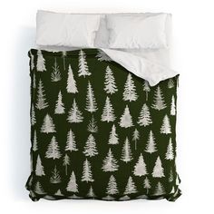 a bed with green and white trees on it