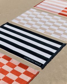 four different colored rugs laid out on the ground with one black and white checkerboard pattern