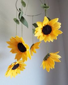 three sunflowers are hanging from a wire