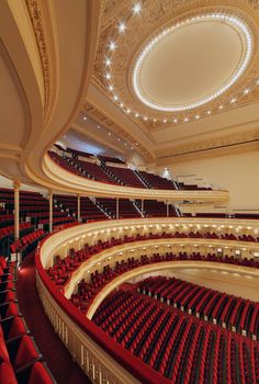 an empty auditorium with red seats and chandelier