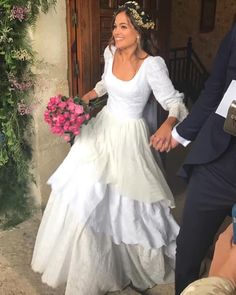 a woman in a wedding dress walking down the street