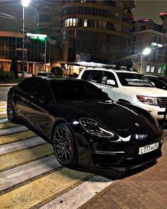 several cars are parked on the street at night