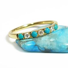 This Turquoise and diamond ring is a beautiful way to say “I love you.” Handmade from 14 karats yellow gold, this stacking ring features seven rounded gemstones alternating between 0.1-carat diamonds and bright blue turquoise.#jonjonjewel #BohoStackableRing,Gold #TurquoiseRing #TurquoiseRingforWomen #TurquoiseJewelry #TurquoiseDiamondRing #TurquoiseStackableRing Turquoise Multi-stone Ring For Gift, Turquoise Diamond Rings With Gemstones, Turquoise Multi-stone Ring Fine Jewelry, Fine Jewelry Turquoise Multi-stone Ring, Stackable Turquoise Ring In Fine Jewelry Style, Stackable Turquoise Ring Fine Jewelry, Turquoise Diamond Ring With Diamond Accents As Gift, Turquoise Diamond Ring As A Gift, Turquoise Diamond Ring As Gift