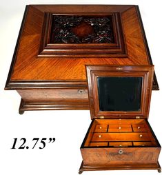 a wooden jewelry box sitting on top of a white floor next to a wall clock