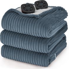 three electric heated blankets stacked on top of each other with two remotes sitting on top