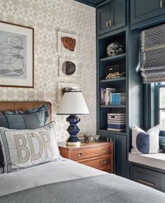 a bed room with a neatly made bed next to a book shelf filled with books