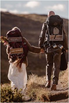 two people walking down a hill holding hands