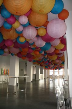 many colorful paper lanterns are hanging from the ceiling