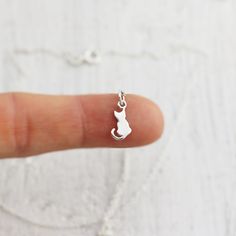 Tiny Sterling Silver Sitting Cat Necklace. This charm necklace featuring a sweet kitty sitting patiently with a tiny curled tail is just the thing for animal lovers. Take this little cat home with you and it will be sure to bring a smile to your face and warmth to your heart! » Sterling Silver Cat Charm (15mm x 6mm) with tiny 925 genuine Sterling mark on back. » Sterling Silver Cable Chain (select from drop-down on upper right) » Your jewelry purchase will come beautifully packaged for gift givi Cat Necklace Gold, Cat Charm Necklace, Cat Necklace Silver, Lovers Jewelry, Lover Necklace, Cat Pendant Necklace, Tiny Cats, Pendant Necklace Simple, Minimalist Accessories