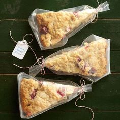 three pieces of cake wrapped in plastic on top of a wooden table next to a tag