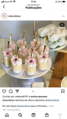 several desserts on a cake stand with flowers in the top and gold sticks sticking out of them