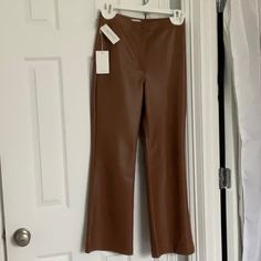 Aritzia Wilfred Adele High Rise Kick Flare Leather Look Pants Look And Feel So Much Like Real Leather You Would Never Know They Aren’t. They Are In The Cognac Shade ( True Colour Shown On Model Photos.) They Have A Front Zip Popper And Button Fly And Two Darts At The Back For A Tailored Fit Into The Waist . Brand New And Hung Up With Cottonwool Pads So Hanger Doesn’t Leave Marks On Waistband. Giftable Condition. Brown Leather Spring Pants Full Length, Brown Leather Full-length Pants For Spring, Brown Full-length Leather Pants For Spring, Brown Leather Pants For Spring, Fitted Leather Wide-leg Pants, Fall Brown Wide-leg Leather Pants, Elegant Brown Leather Pants Full Length, Elegant Brown Full-length Leather Pants, Elegant Full-length Brown Leather Pants