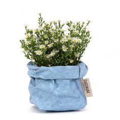 a blue bag filled with flowers on top of a white table