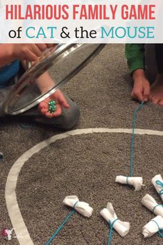 children playing with their cat and the mouse game on the floor in front of a metal pan