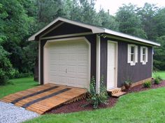 a garage with a ramp leading up to the front door and side windows on top of it