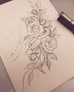 a pencil drawing of flowers on paper next to a pen