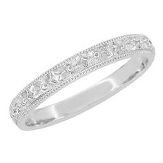 a white gold wedding band with flowers on it