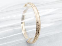 The details on this vintage 14-karat gold bangle are simply stunning! Intricate scrolling botanical designs are engraved in warm yellow gold, covering the entire bracelet. Beautiful on its own or layered with other bracelets this piece is perfect for day or evening wear.Metal: 14K Yellow GoldWidth: 6.3 mmInside Circumference: 6 1/2 InchesMarks: "JW 14K" Stamped on the inside band Classic Ceremonial Bracelet With Intricate Design, Formal Heirloom Yellow Gold Cuff Bracelet, Elegant Yellow Gold Bracelet With Decorative Band, Formal Yellow Gold Bracelet With Decorative Band, Elegant Gold Bangle Bracelet For Ceremonial Occasions, Classic Cuff Bracelet With Intricate Design For Anniversary, Elegant Bracelet With Decorative Band For Anniversary, Elegant Gold Bracelet With Decorative Band, Gold Etched Cuff Bracelet For Wedding