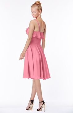 a woman in a pink dress is posing for the camera with her hands on her hips