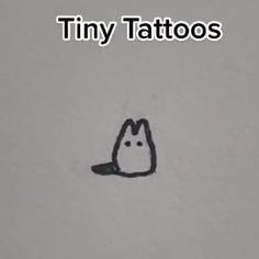 the tiny tattoo has been drawn in black ink on white paper with an image of a cat's head