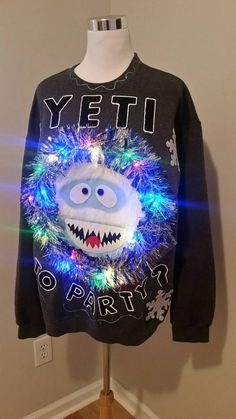 a sweater with lights on it that says yet to party in front of a white wall