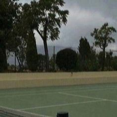 a tennis court with trees in the background