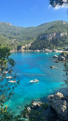 boats are in the clear blue water near mountains